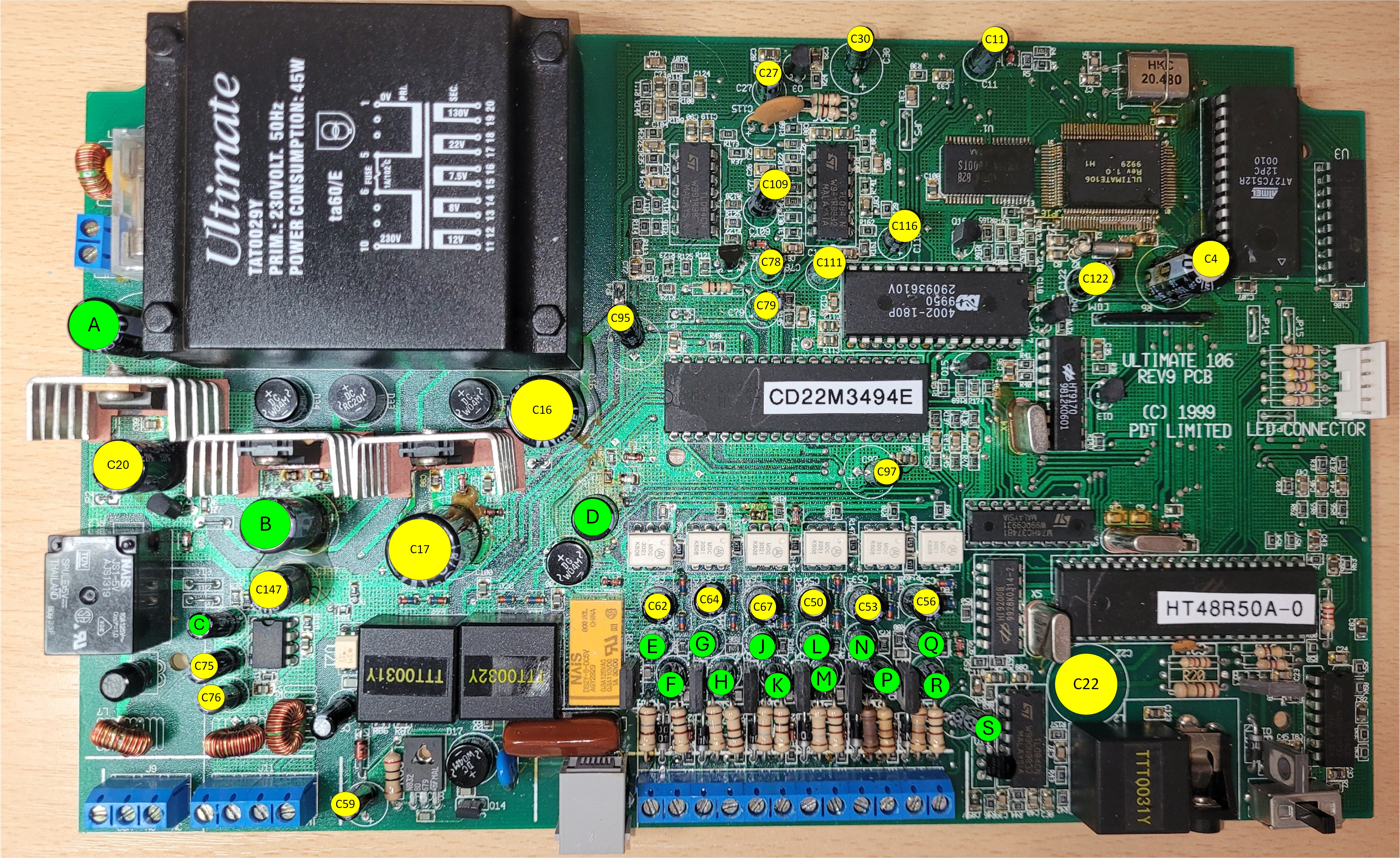 Ultimate 106 PCB with all 43 electrolytic capacitors annotated — yellow labels show visible silkscreen references, green labels indicate hidden references