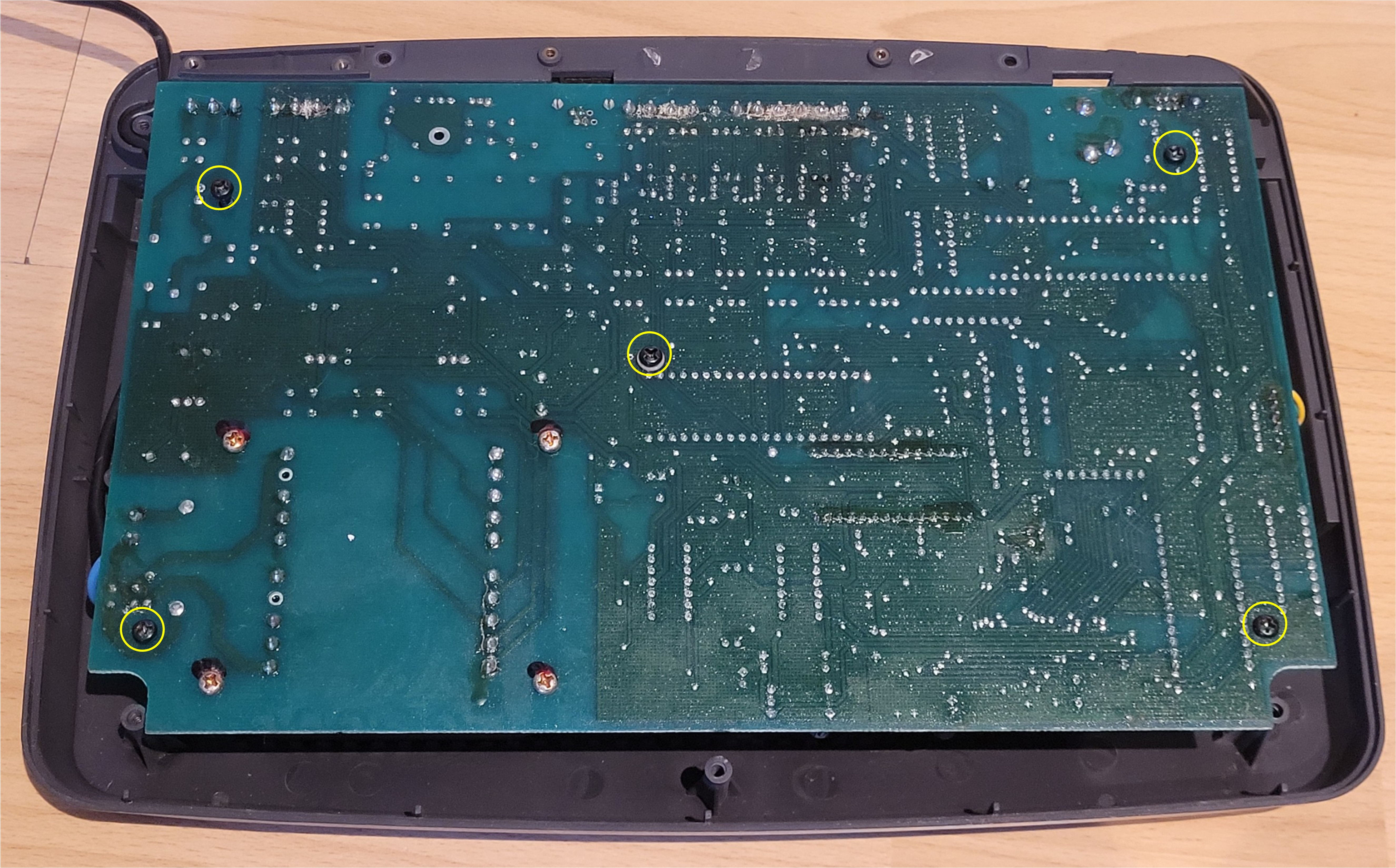 Solder side of the Ultimate 106 PCB showing the four self-tapping screws (highlighted in yellow) that secure the board to the rear case
